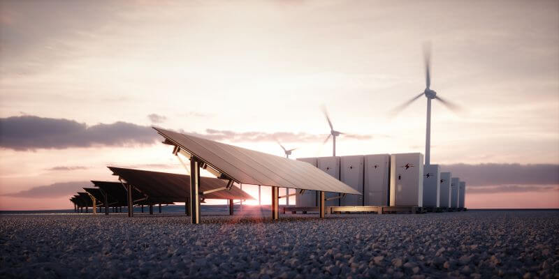 Image of solar panels, battery storage systems and wind turbines co-located